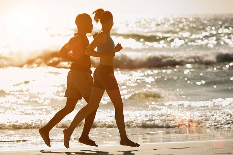 barefoot runners on the beach
