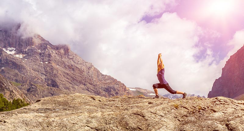 woman doing yoga on mountain