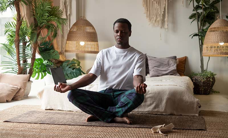 man doing pranayama breathing in bedroom