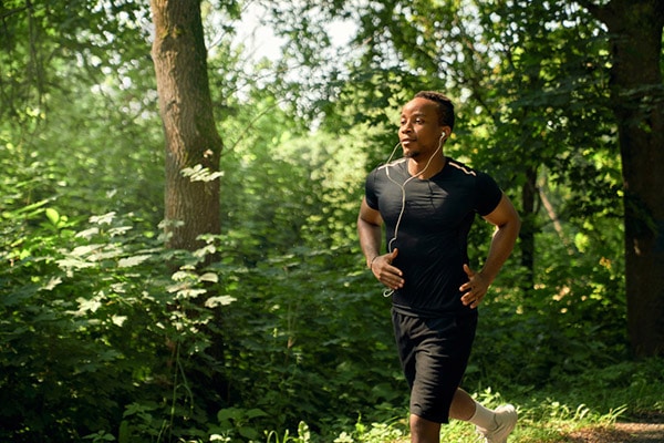 guy running in forest with earbuds