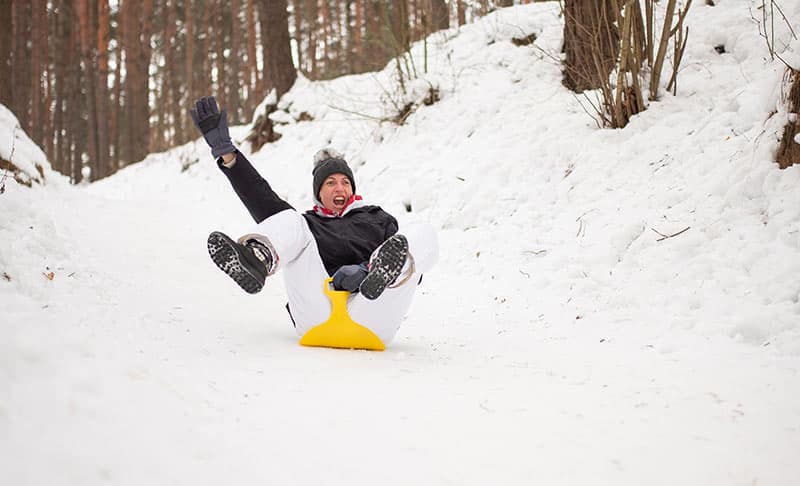 Getting Started With Sledding (For Fitness!) 1 woman sledding down hill